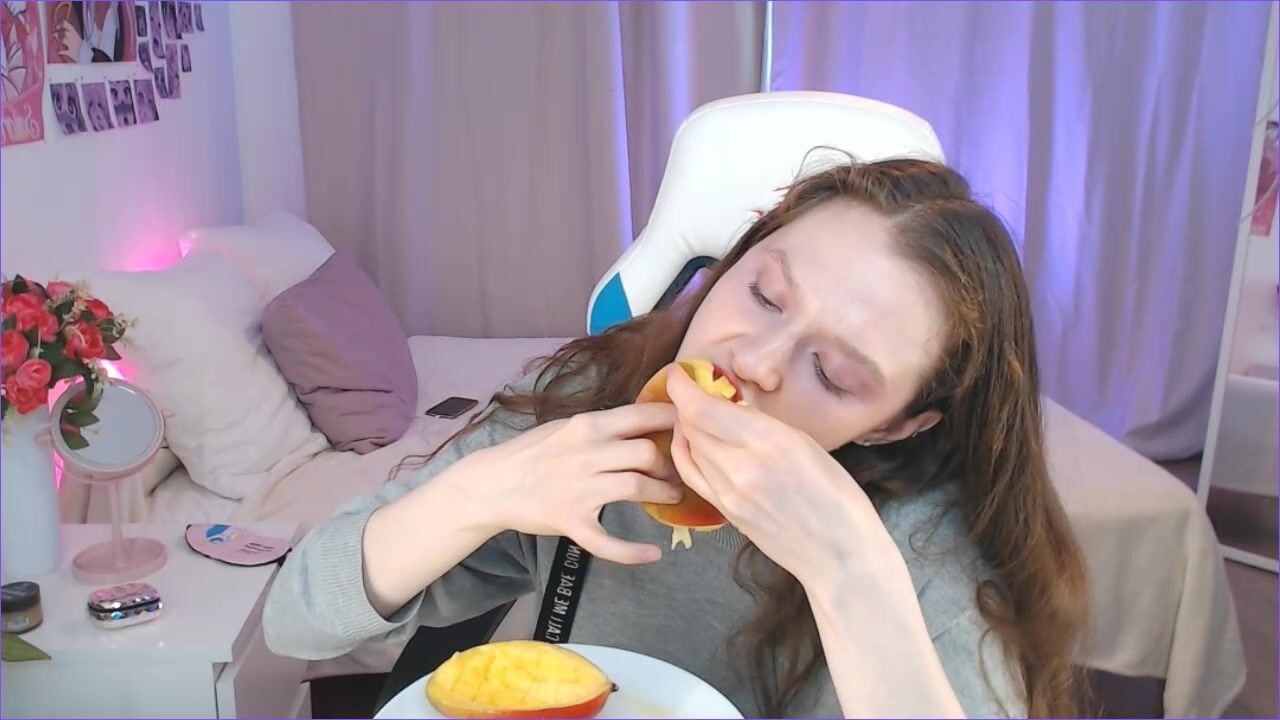 cute redhead eating juicy mango