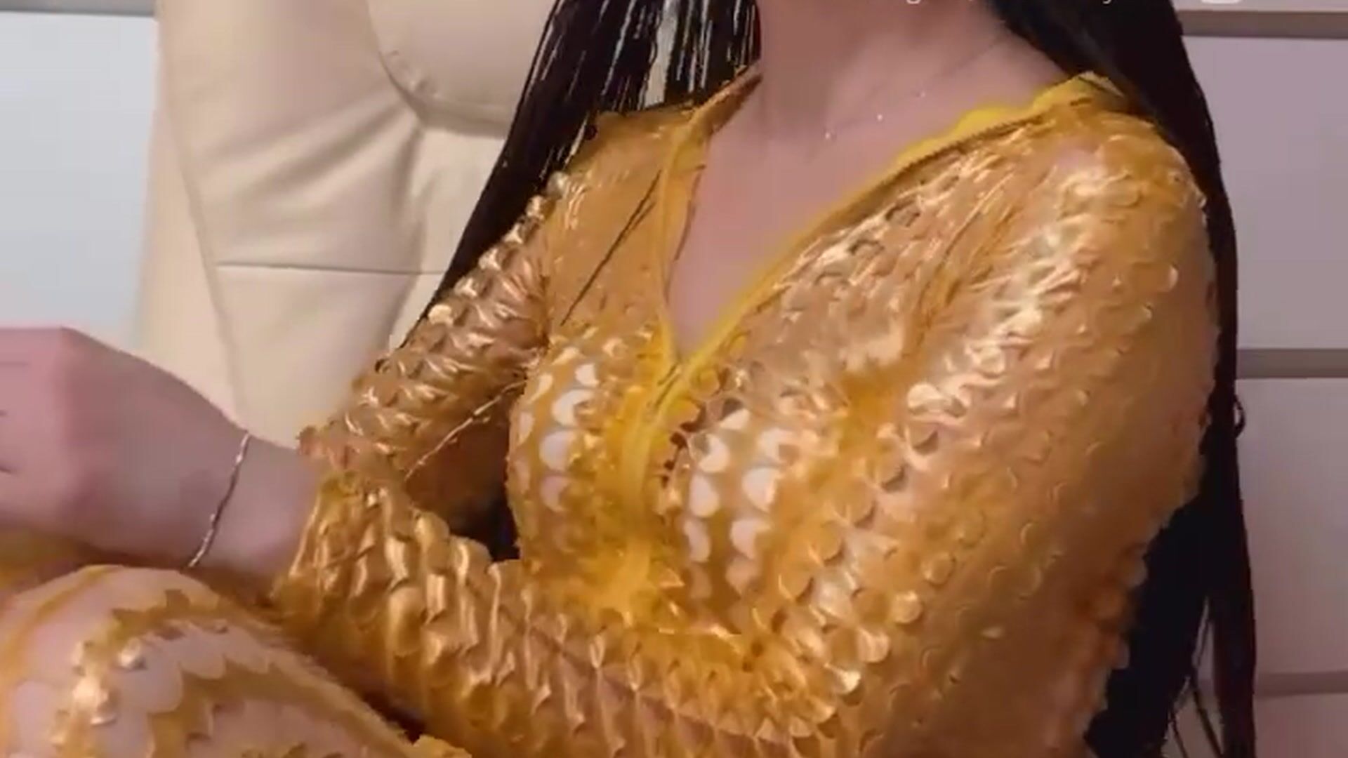 In a gold jumpsuit